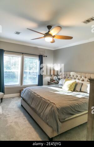 Spacious beige carpeted master bedroom with king sized bed Stock Photo