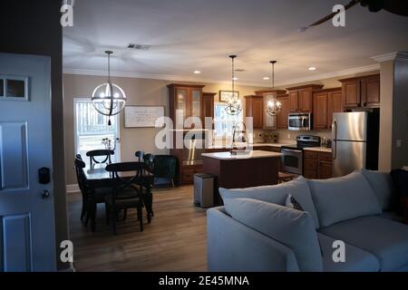 Small renovated dark wood kitchenwith view of dining and living room Stock Photo