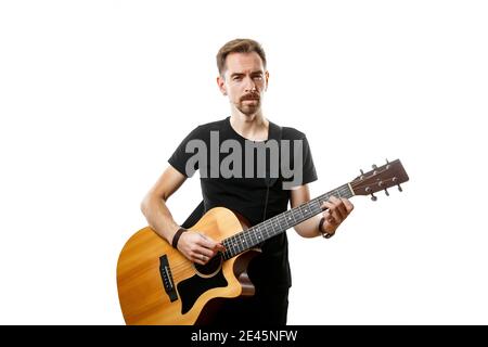 The young man plays the guitar. Isolated white background Stock Photo