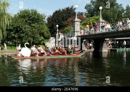 A swan boat on the lagoon by the foot bridge at the Public Garden on a summer day in Boston, Massachusetts, USA. Stock Photo