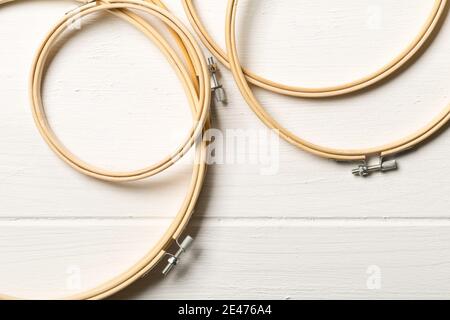 Set of round embroidery or stitching frames on white wooden table background, flat lay top view from above Stock Photo