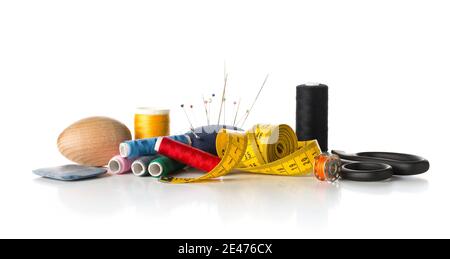 Collection of sewing tools with yarn, needles, scissors and tape measure over white background Stock Photo