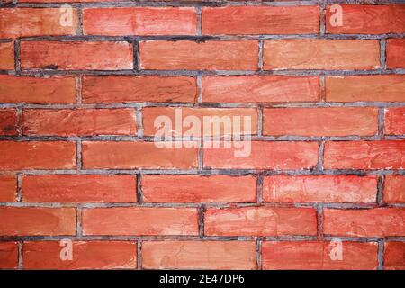 Red grunge brick in the wall with gray putty. Brick screen saver Stock Photo