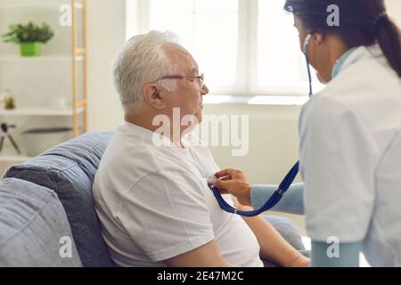 Doctor listening to the heart and breathing of an older man through a stethoscope on his chest. Stock Photo