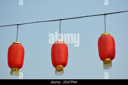 Three bright red lanterns hang on display in a Hangzhou street prior to the Chine New Year celebrations. Stock Photo
