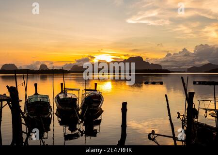 Ban Sam Chong Tai and colorful sunrises that emerges behind the giant limestone mountains, Phang-nga, Thailand Stock Photo