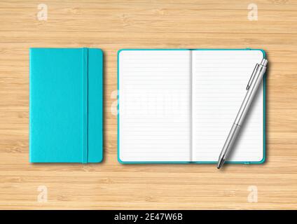 Aqua blue closed and open lined notebooks with a pen. Mockup isolated on wooden background Stock Photo