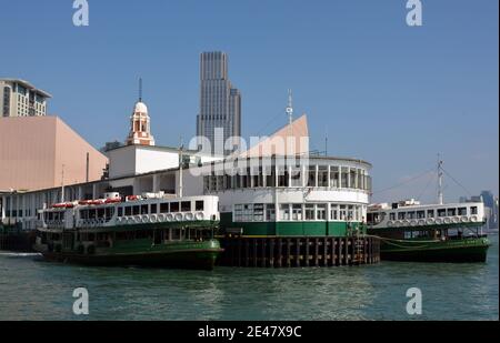 Star ferries on the Kowloon public pier. The famous boats take passengers across to Hong Kong efficiently and cheaply. Stock Photo