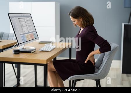 Back Pain At Work. Bad Computer Posture Stock Photo