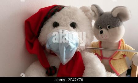 Teddy bear with surgical mask and mouse Stock Photo