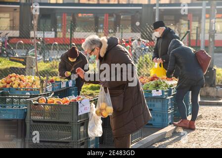 Prague, Czech Republic. 01-21-2021. People bying fruits and vegetables at the market, in the center of Prague during a sunny winter morning. Stock Photo