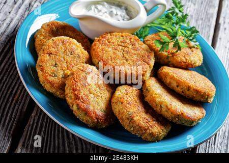 Easy fish cakes of white fish fillet: cod or haddock with potato and parsley, breaded in breadcrumbs served on a plate with tartar sauce in a gravy bo Stock Photo