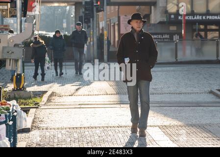 Prague, Czech Republic. 01-21-2021. Man walking in the center of Prague during a sunny winter morning, close to a fruit and vegetable market. Stock Photo