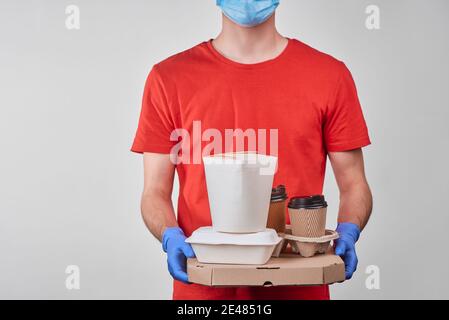 Delivery man holding a pile of packaged food Stock Photo