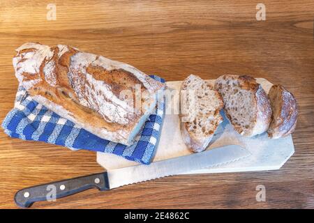 Traditional French bread on a wooden board with knife Stock Photo
