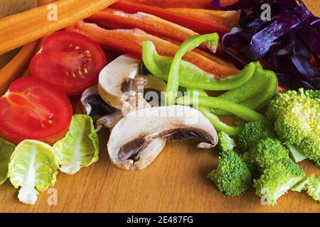 Closeup shot of sliced fresh  vegetables on a light brown background Stock Photo