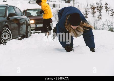 Two friends fighting with snowballs in the snow with the 4wd car on the background Stock Photo