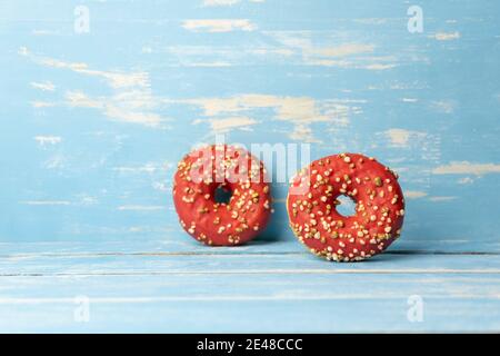Two red donuts on rustic blue wooden background Stock Photo