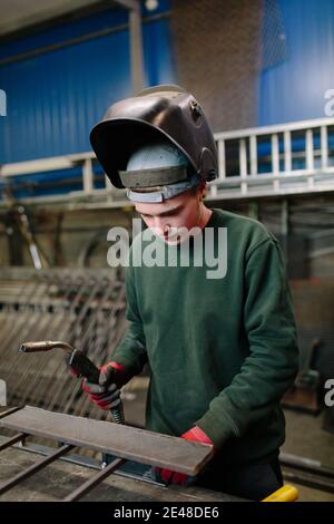 Welder at work getting ready for welding in workshop. Welder in his workshop. Stock Photo