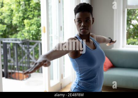 African american woman performing stretching exercise at home Stock Photo