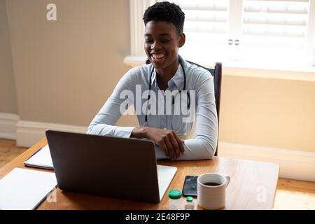 African american female doctor making video consultation call using laptop