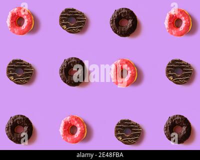 Colorful round donuts on violet background. Flat lay, top view. Stock Photo
