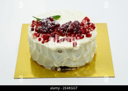 Cake sprinkled with pomegranate berries. Cake on a white background. Stock Photo