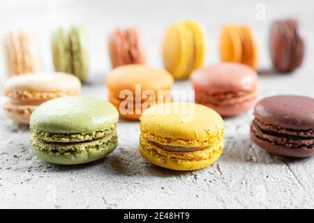 Multicolored delicious French macaroons or macarons lying in on a gray surface Stock Photo