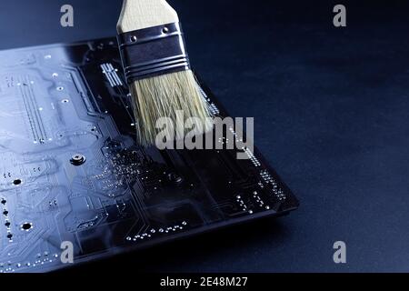 Motherboard. Disassembled laptop. Cleaning dust from a computer with a brush. Repairs Stock Photo