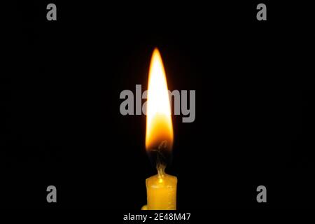 Close up single candle light and flame on black background Stock Photo