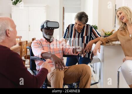 Senior caucasian and african american couples sitting on couch using vr headset at home Stock Photo