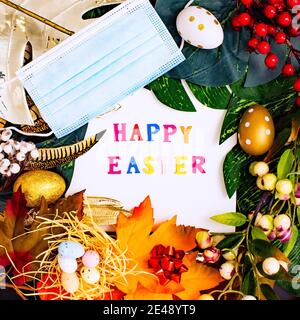 Happy Easter. Congratulatory easter background. Easter eggs and flowers. Flat lay. Nature concept. Stock Photo