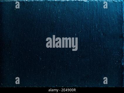 Black slate board on dark stone texture top view. Black textured slate board on dark background Stock Photo