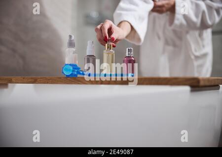 Cropped photo of lady arranging her cosmetics in the bathroom Stock Photo