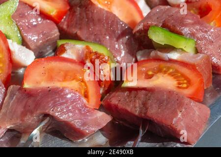 Raw beef and vegetables brochettes on a dish Stock Photo