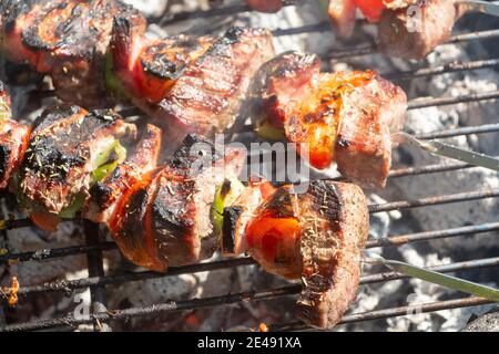 Beef and vegetables brochettes grilling on barbecue Stock Photo