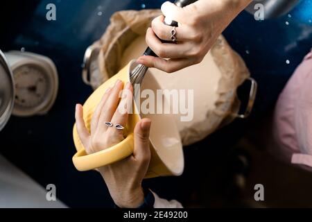 Putting in a pot the cream of a cheesecake. Homemade Stock Photo