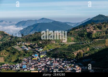 view of the village at the foot of the mountains with a sea of clouds in central java, Indonesia from the top early in the morning Stock Photo