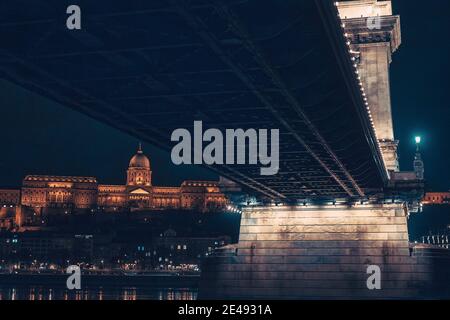 Unique view from below the Chain Bridge (lanchid) at Night witht Castle in the Background- Budapest, Hungary Stock Photo