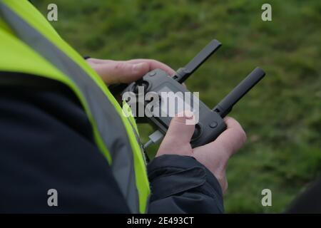 Selective focus shot of a drone pilot flying a drone using a remote control Stock Photo