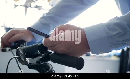 Man on the Bicycle Text Using Cellphone and Access Network Online Applications, Biker Typing a Message on Mobile Stock Photo