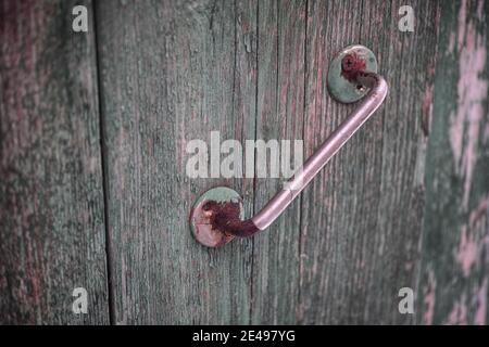 An old rusty doorknob on a wooden door. Close up. Stock Photo