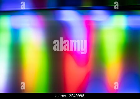 Abstract close-up of defocused yellow, green, red, magenta, and blue effect created by LED lights photographed outdoors at night. Stock Photo