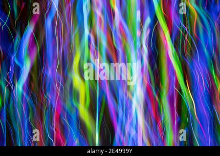 Abstract effect of dynamic multi colored shapes in varying thickness created by LED lights photographed outdoors at night. Stock Photo
