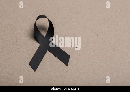 Melanoma awareness ribbon on black color background. Mourning and ...