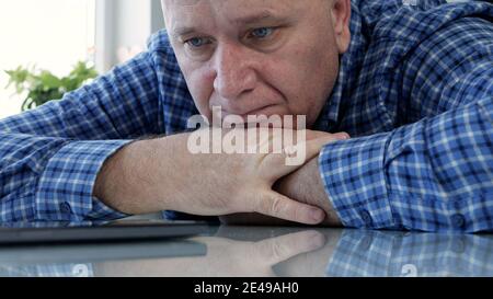 Sad Elderly Person Isolated in Quarantine at Home Looking Bored and Disappointed to a Cell Phone Stock Photo