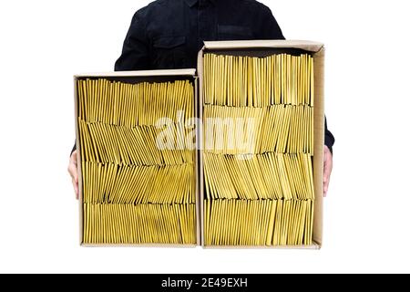 Man in black uniform holding two cardboard boxes with yellow padded bubble envelopes of different size isolated on white. Stock Photo