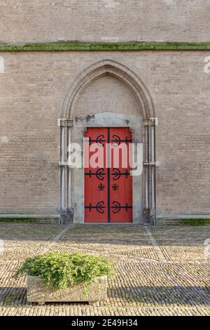 Background with ancient brown red door in brick wall Stock Photo