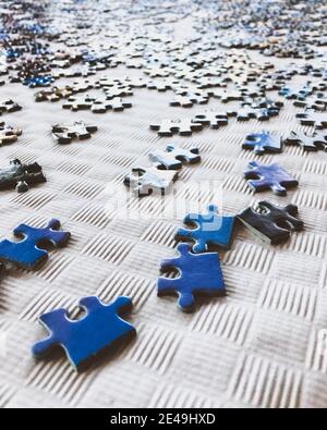 messy puzzle pieces on a white table Stock Photo