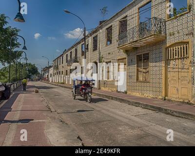 Iquitos, Peru- Dec14, 2017: Dilapidated colonial houses covered with ceramic tiles along a street in a small town in the middle of the Amazon jungle, Stock Photo